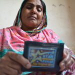 Nasri Bibi weeps as she holds her son's wallet, found at the Ali Enterprises factory where he was killed.