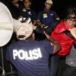 A protestor comes under attack from police. 